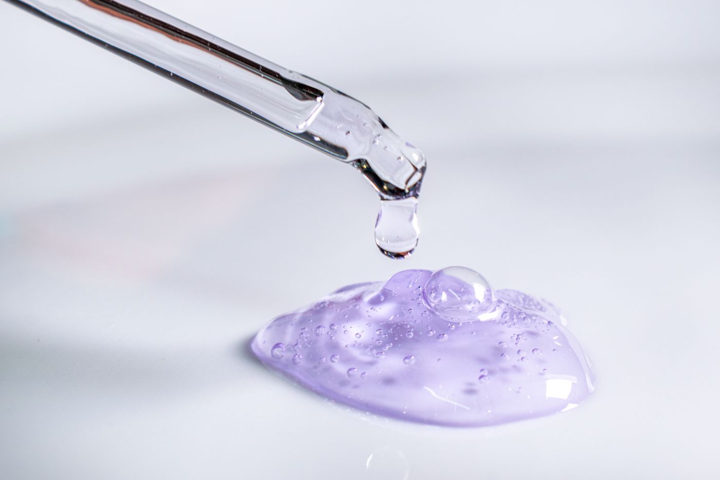 Pipette dispensing a drop of serum gel, clinical skincare development