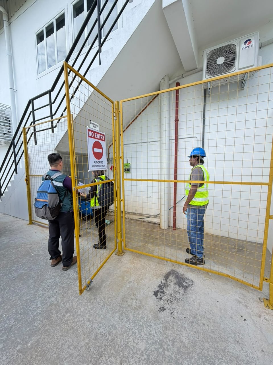JKKP officers checking the fenced restricted-access compressor area outside the ORIZI Group plant