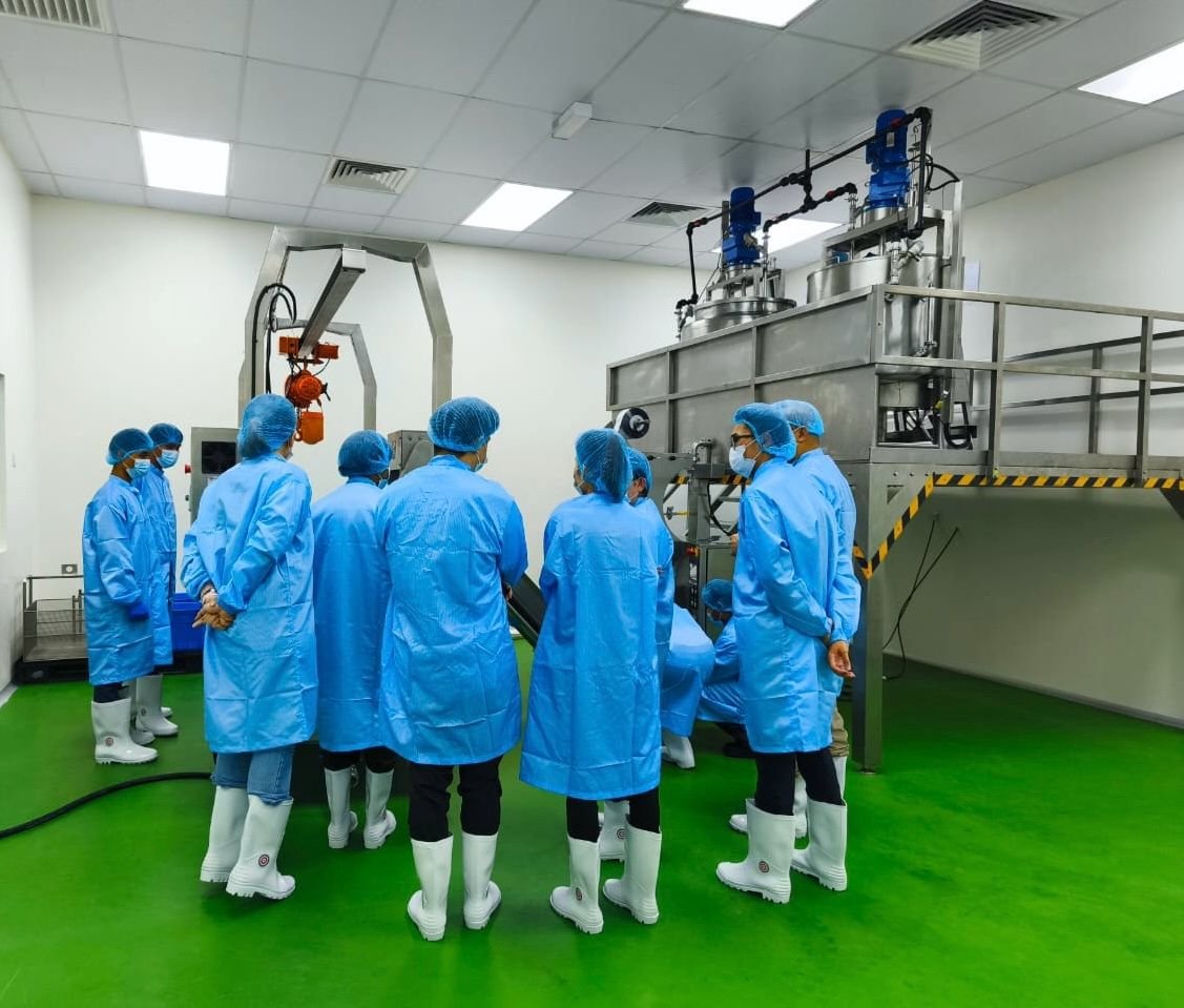 Client team in cleanroom gowns touring the production floor at Nutrizens, an ORIZI Group facility