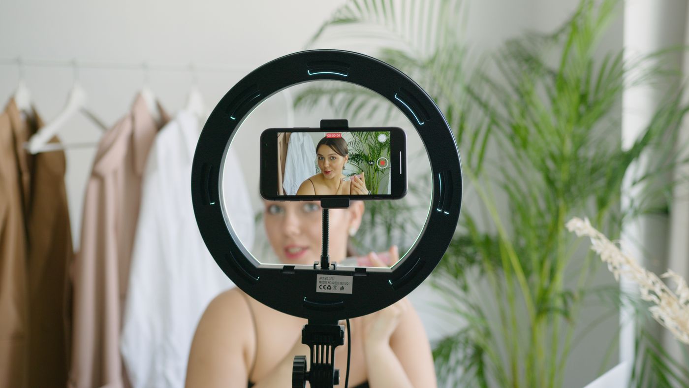 Creator filming product content with a smartphone on a ring light